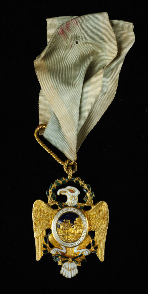 Click for a larger view. Gold insignia of the Society of the Cincinnati on a faded blue ribbon