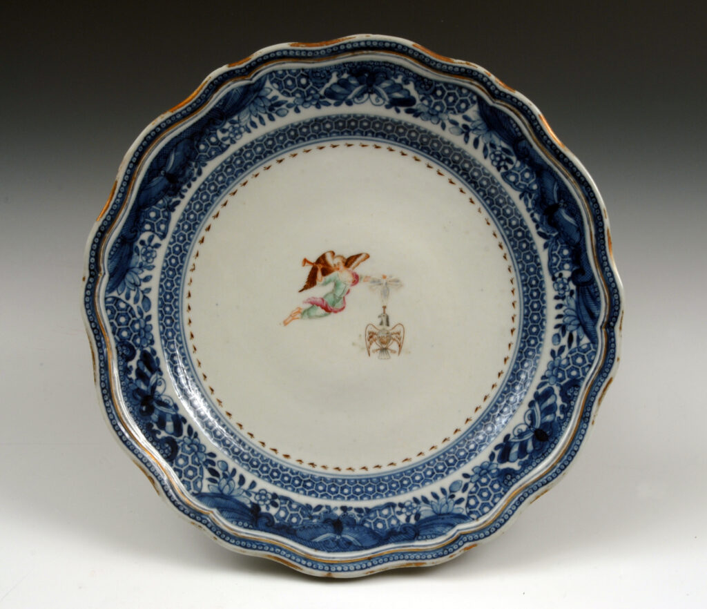 Society of the Cincinnati porcelain dinner plate with blue border and winged female figure holding a trumpet and eagle-shaped medal suspended from a ribbon